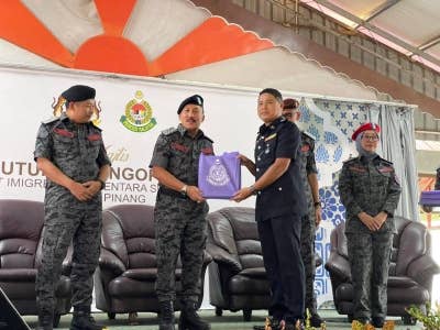 Ruslin (dua dari kanan) menyampaikan cenderamata sebagai penghargaan kepada petugas Depot Sementara Sungai Bakap Majlis Penutupan Pengoperasian Depot Imigresen Sementara Sungai Bakap Pulau Pinang dan Majlis Berbuka Puasa pada Jumaat.
