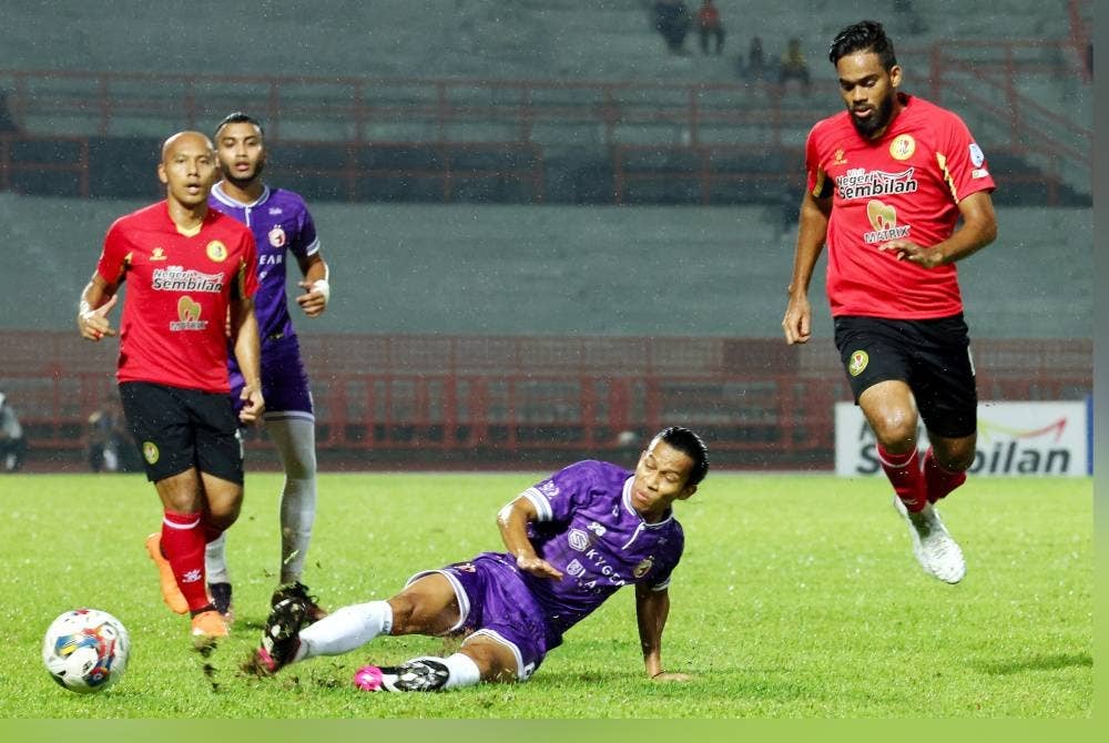 Pemain Kelantan FC, Ahmad Khairil Anuar (dua dari kanan) mengeluarkan bola dari dirampas oleh pemain Negeri Sembilan Aroon Kumar (kanan) pada perlawanan Liga Super di Stadium Tuanku Abdul Rahman, Paroi pada Sabtu. - Foto Bernama