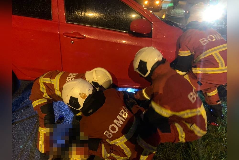 Anggota Bomba dan Penyelamat sedang mengeluarkan mangsa tersepit di bawah kereta dalam kemalangan di Jalan Utama Bandar Country Home, Rawang pada Ahad.