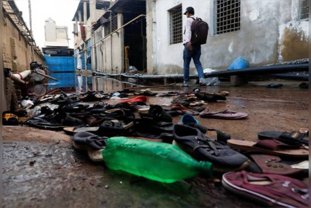 Kasut dilihat bergelimpangan susulan kejadian rempuhan di Karachi, Pakistan. - Foto Reuters