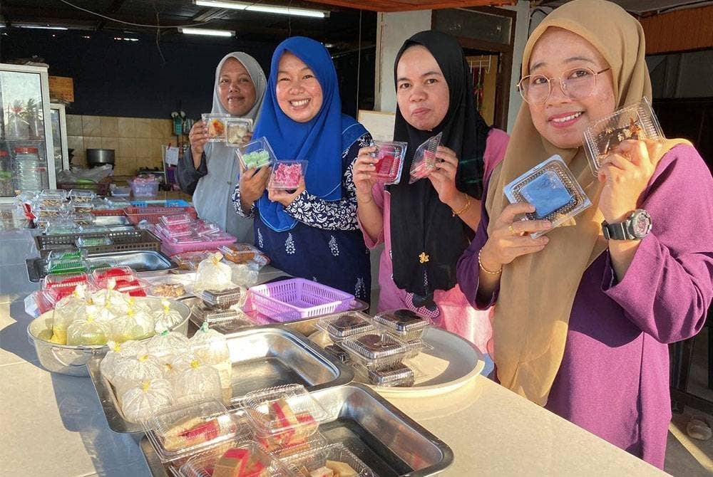 Empat anak perempuan Siti Maimunah menunjukkan sebahagian daripada 1,000 peket kuih-muih yang dijual dengan harga RM1.