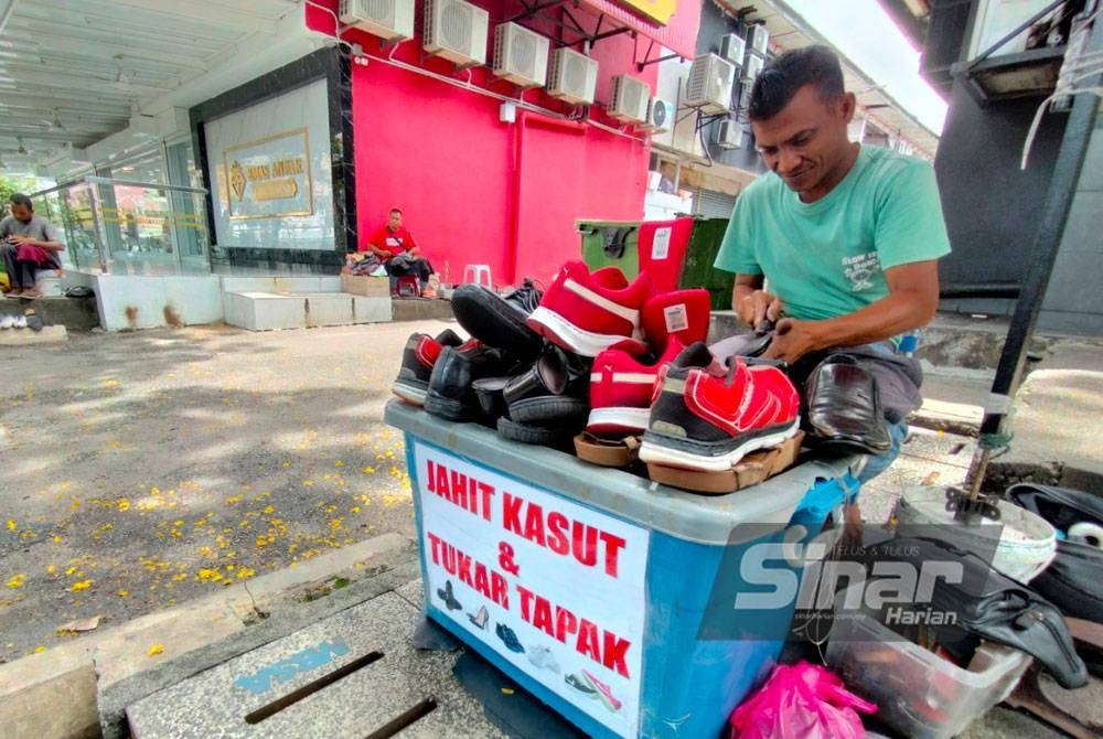 Edi Ali membaiki kasut yang dihantar pelanggan di Seksyen 18, Shah Alam.