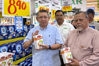 Salahuddin Ayub (kiri) menunjukkan antara barangan keperluan untuk Aidilfitri yang dijual dengan harga yang rendah di sebuah pasaraya dalam menyahut saranan kerajaan untuk mengadakan Jualan Rahmah pada Ahad. - Foto: Bernama