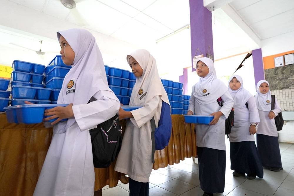 Pelajar beratur untuk mengambil makanan menerusi Program Makanan Kesihatan (PROMAK).