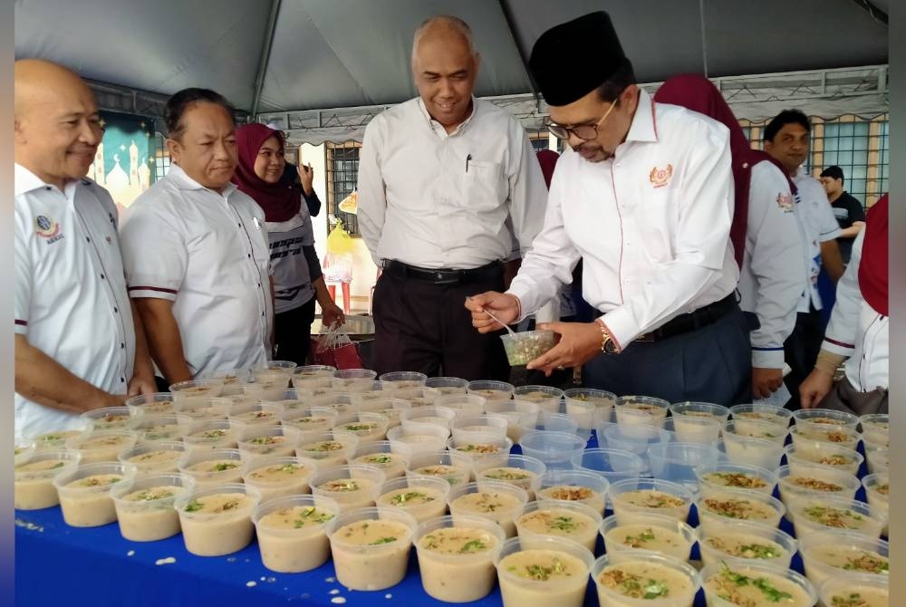 Adnan (kanan) ketika Program Ihya Ramadan Gotong-royong Memasak dan Edaran Bubur Lambuk AUEG AS Negeri Perak di Anjung AUEGCAS Perak di sini pada Isnin.