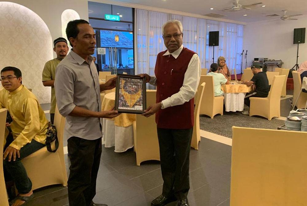 Sivanesan (kanan) menerima cenderahati daripada Pengerusi Persatuan Pengamal Media Perak, Sayed Mohd Hesham Sayed Idris ketika Majlis Berbuka Puasa Bersama Media Perak di sebuah restoran di sini pada Isnin.