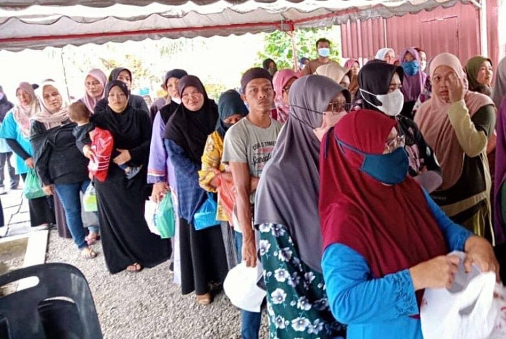 Penerima beratur untuk mendapatkan air balang yang ditaja oleh FR Qaseh.