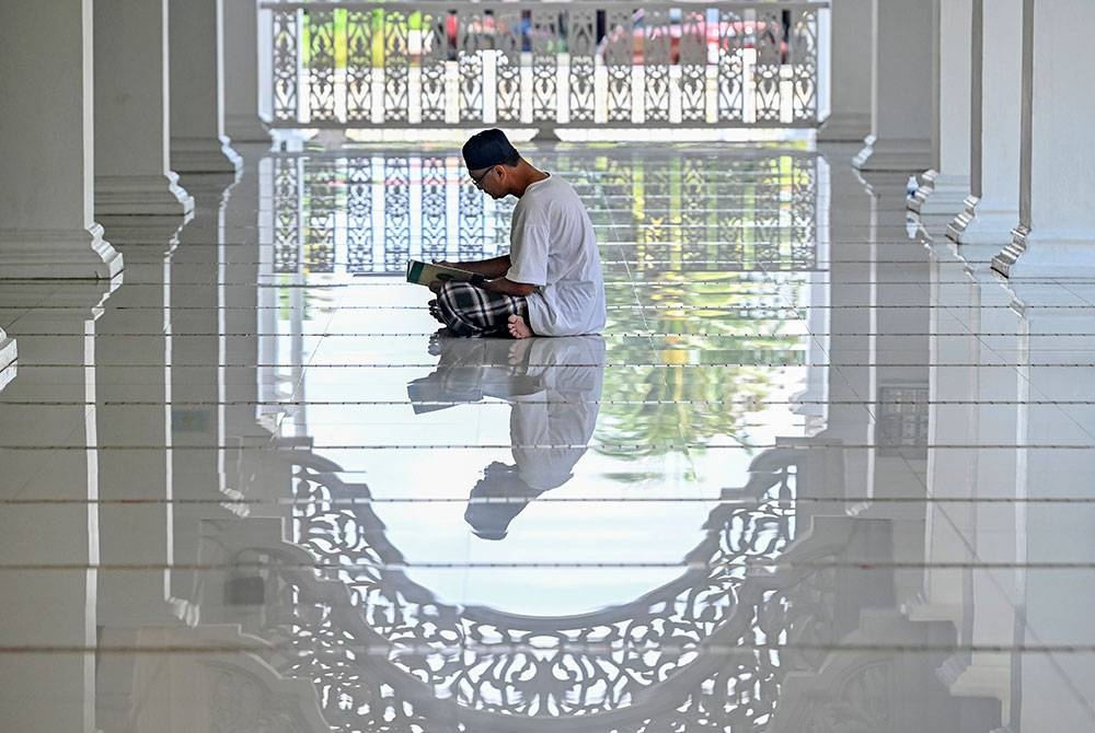 Seorang lelaki membaca Al-Quran sempena Ramadan di Masjid Sultan Ismail hari ini.