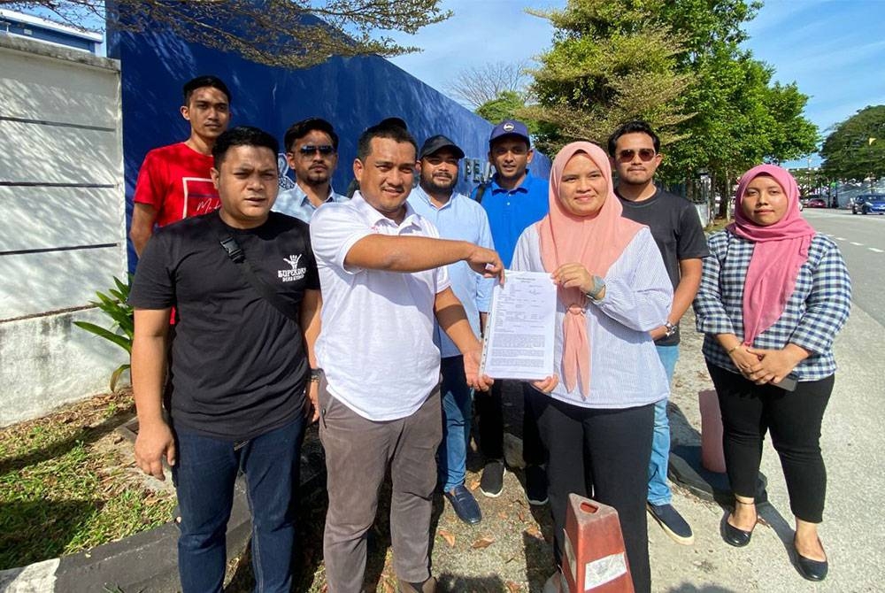 Mohd Fakhrul Akhmal (dua dari kiri) menunjukkan laporan polis dibuat di IPD Pekan pada Selasa.