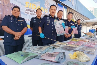 Mohd Yusri menunjukkan dadah yang dirampas dalam serbuan makmal haram dadah di Pantai Remis, Manjung pada Sabtu lalu.