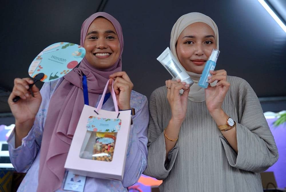 Pengunjung menunjukkan pek produk percuma dan kit Iftar sempena program Iftar ala Madinah @Karangkraf.