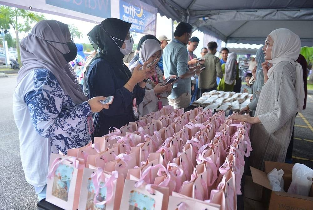 Pengunjung hadir di reruai syarikat Pharmacore Technology & Innovation Sdn Bhd untuk mendapatkan pek produk percuma dan kit Iftar ala Madinah