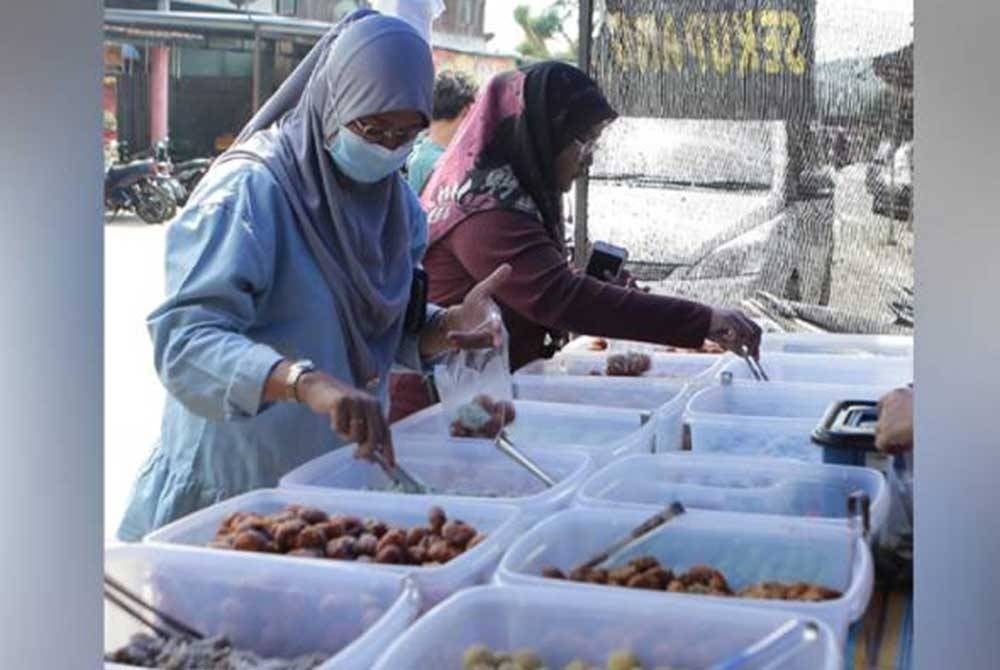 Dua pelanggan sedang memilih kuih-muih yang dijual pada harga sekupang atau 10 sen di gerai Roslina Saad di Bazar Ramadan Lubuk Merbau, Padang Terap, Kuala Nerang, Kedah. - Foto Awani
