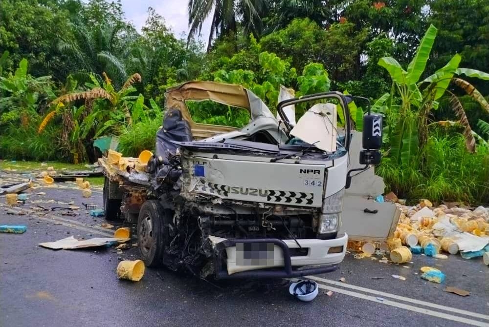 Seorang pemandu lori yang membawa muatan mentega maut digilis selepas tercampak apabila kenderaan yang dipandunya bertembung dengan sebuah lori balak berdekatan Sekolah Meratu-Jalan Lama Gua Musang pada Rabu. - Foto JBPM