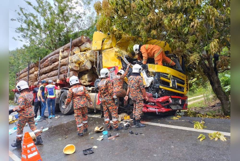 Pemandu lori balak berkenaan mengalami kecederaan pada kaki akibat tersepit. - Foto JBPM