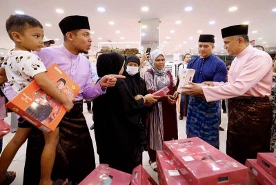 Pengarah Urusan Kumpulan Jakel, Datuk Seri Mohamed Faroz Mohamed Jakel (kanan) bersama selebriti yang juga duta tekstil Jakel, Aaron Aziz (dua, kanan) dan Nabil Ahmad (kiri) melayani pelanggan pada majlis pelancaran lokasi baharu gedung tekstil di Seksyen 7, hari ini. 