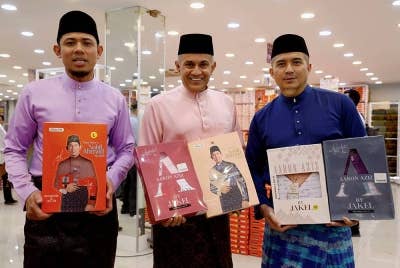 Pengarah Urusan Kumpulan Jakel, Datuk Seri Mohamed Faroz Mohamed Jakel (tengah) bersama selebriti yang juga duta tekstil Jakel, Aaron Aziz (kanan) dan Nabil Ahmad menunjukkan koleksi baharu baju Melayu pada majlis pelancaran lokasi baharu gedung tekstil di Seksyen 7. - Foto Bernama.