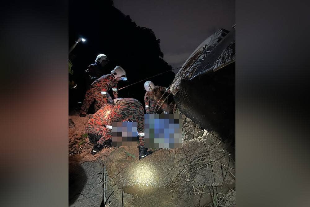 Anggota bomba menjalankan operasi mengeluarkan mayat kedua-dua mangsa yang terperangkap dalam jengkaut terbalik di Simpang Pulai. - Foto Ihsan JBPM Perak
