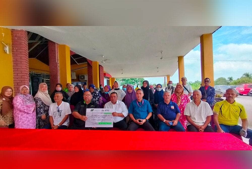 Hameed (enam dari kiri) bersama sebahagian penerima selepas Penyerahan Sumbangan Hari Raya Aidilfitri Tabung Haji Peringkat DUN Ayer Limau pada Khamis.