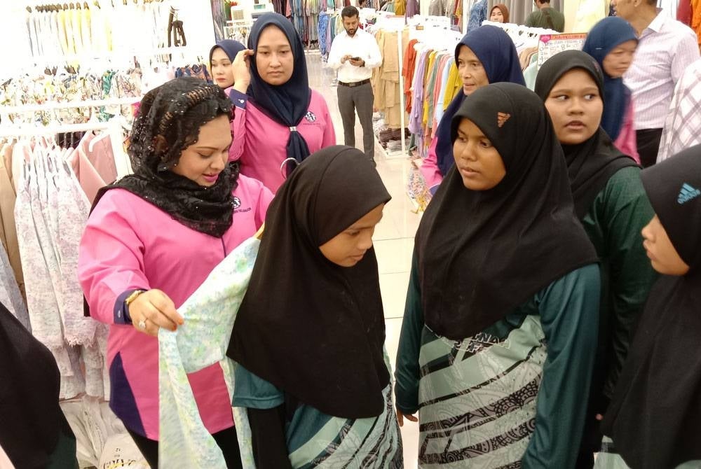 Pengerusi Perkep Selangor Datin Liliyana Haryanti Mohd Harunizam beramah mesra bersama anak yatim ketika program sumbangan Aidilfitri di gedung tekstil Jakel cawangan Shah Alam, Seksyen 7 di sini pada Jumaat.