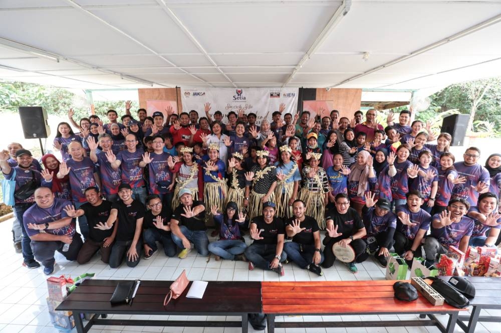 Sukarelawan yang menyertai Program Sincerely Setia Volunteer Weekend bergambar beramai-ramai bersama komuniti Orang Asli Bukit Tampoi.