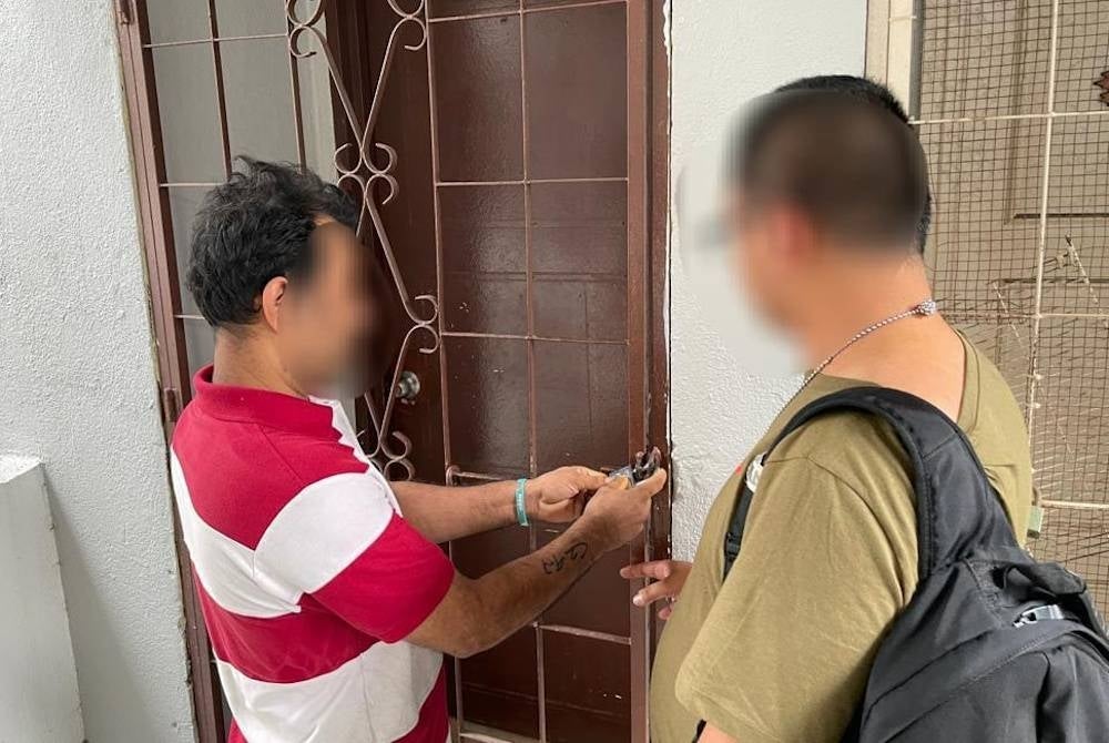 Seorang petugas JIM meminta seorang PATI membuka sebuah premis yang dipercayai digunakan membuat pelekat palsu PLKS.