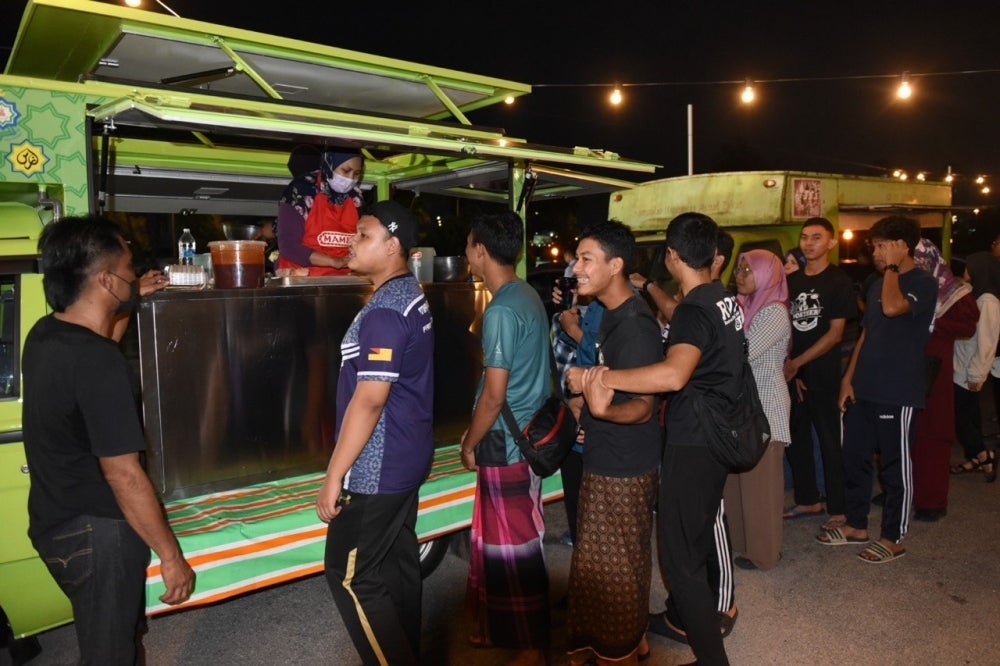 Pengunjung beratur untuk mendapatkan makanan dan minuman yang disediakan.