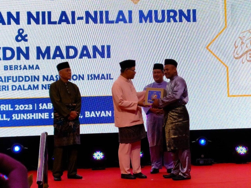 Saifuddin (dua dari kiri) menyerahkan kotak food bank pada Majlis Penerapan Nilai-Nilai Murni dan Iftar KDN Madani di sini, pada Sabtu.
