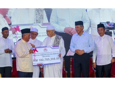 Ahmad Zahid(tiga dari kanan) menyampaikan replika cek kepada wakil peserta Felcra.