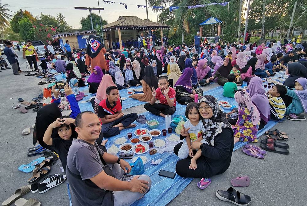Normi (depan, kanan) bersama suami dan anak-anaknya ketika menghadiri Majlis Berbuka Puasa Sekampung di Dataran Tekuk Paku di Kuala Terengganu.