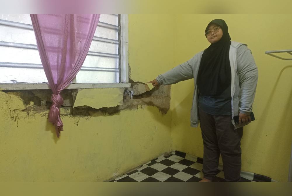 Nurul menunjukkan retakan di dalam bilik akibat insiden rempuhan kenderaan.