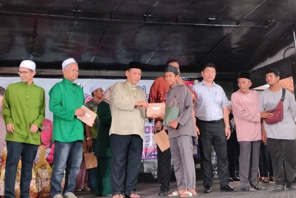 Aminuddin (empat kiri) ketika menyampaikan sumbangan kepada anak yatim terlibat.
