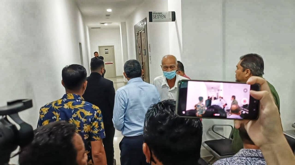 Azlan (dua dari kiri) ketika tiba di Mahkamah Sesyen di Kangar bagi mengikuti sesi pendakwaan terhadapnya.