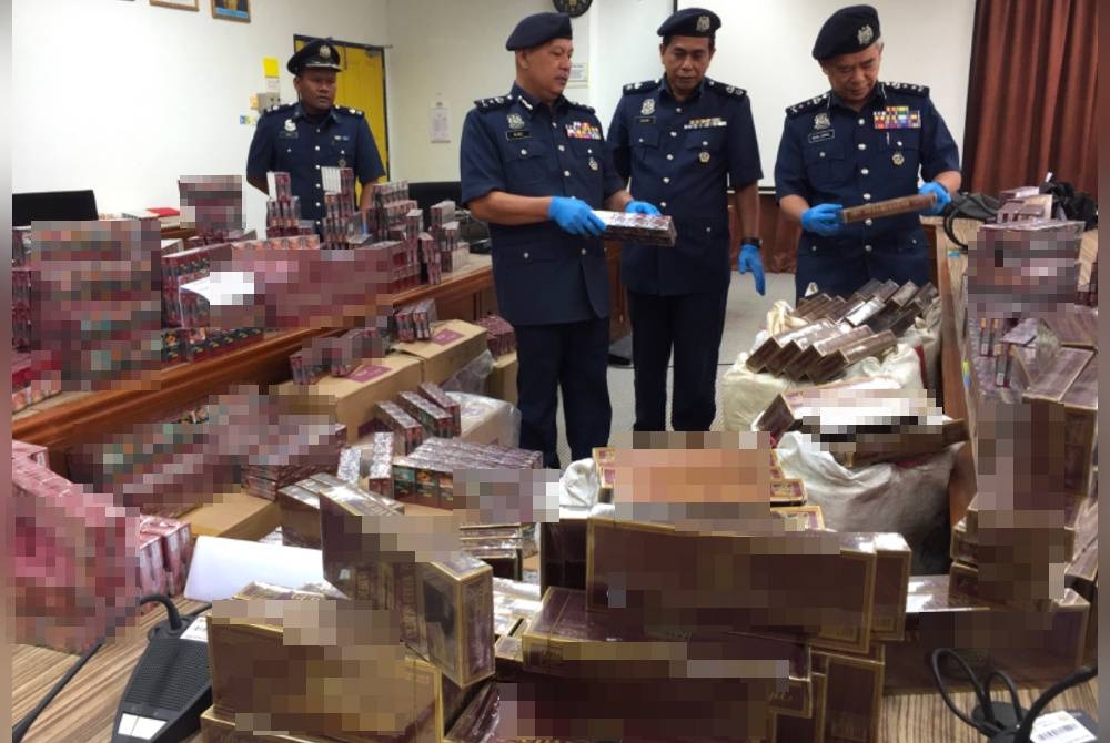 Wan Jamal Abdul Salam (kanan) melihat rokok seludup yang dirampas.