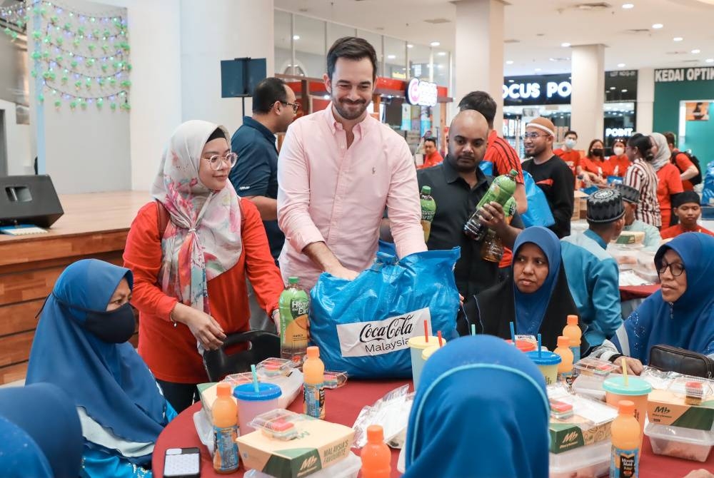 Beberapa warga kerja Coca-Cola menyantuni asnaf yang hadir pada salah satu program yang dianjurkannya sempena bulan Ramadan.