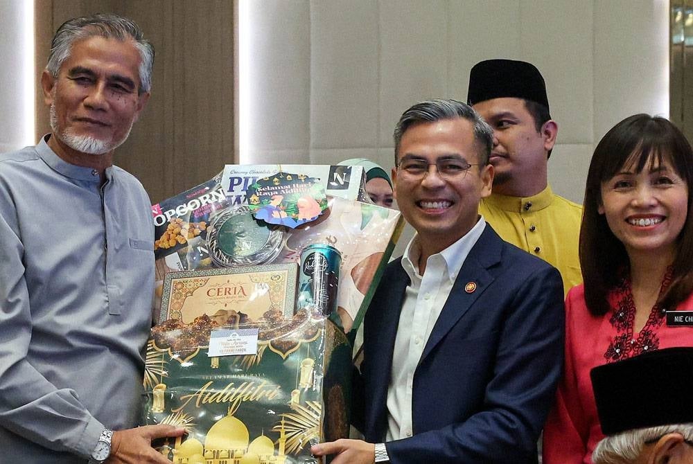 Fahmi Fadzil (tengah) bersama Timbalannya, Teo Nie Ching (kanan) menyerahkan hamper penghargaan dan menyantuni wartawan veteran Bernama, Mohamad Arif Shamsuddin (kiri) pada Majlis Apresiasi Pengamal Media Bersama Fahmi Fadzil di sebuah hotel malam ini. - Foto: Bernama