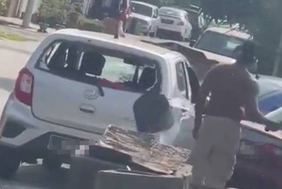 Seorang lelaki bertindak memecahkan cermin kereta jirannya itu di Taman Puchong Perdana, Puchong, Selangor, pada Khamis lepas. - Foto FB NurJannah Sabaruddin