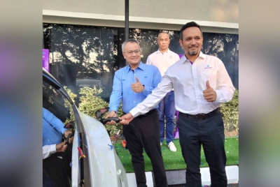 Rick (kiri) menggunakan pengecas EV yang dipasang di Hotel Perdana pada Majlis Pelancaran Pengecas Kenderaan Elektrik oleh PNB pada Ahad.