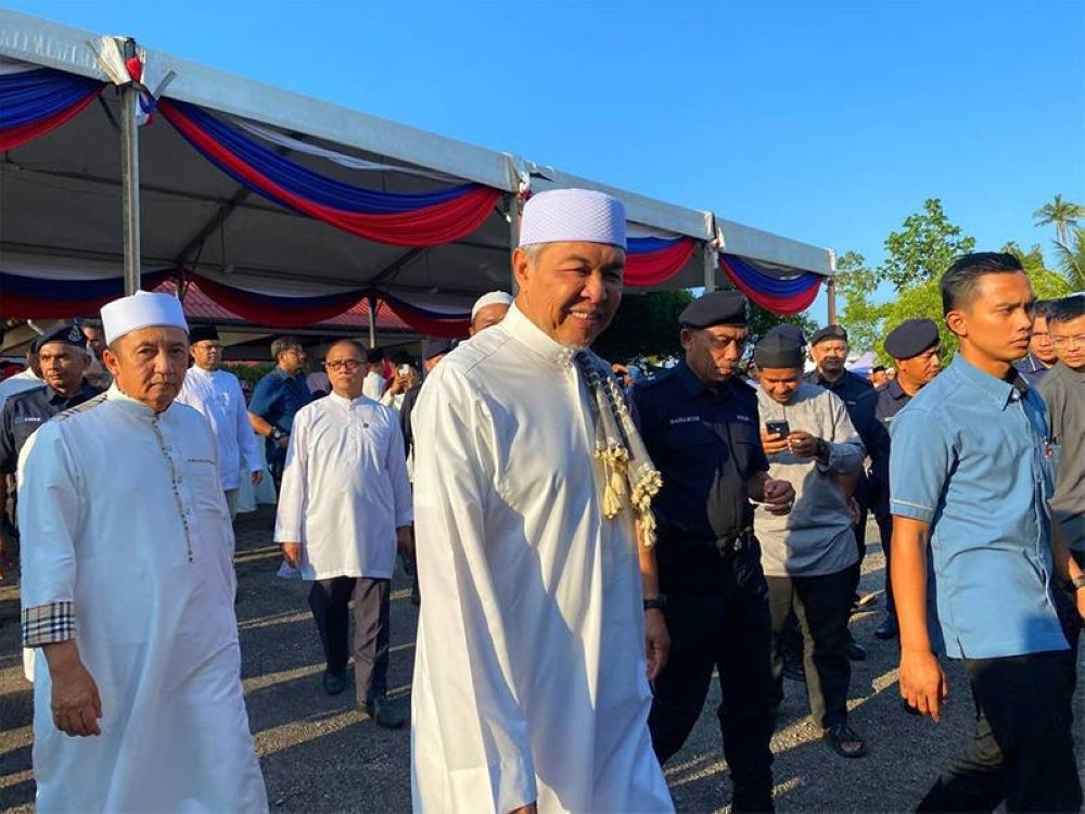 Ahmad Jazlan (kiri) menyambut ketibaan Ahmad Zahid.