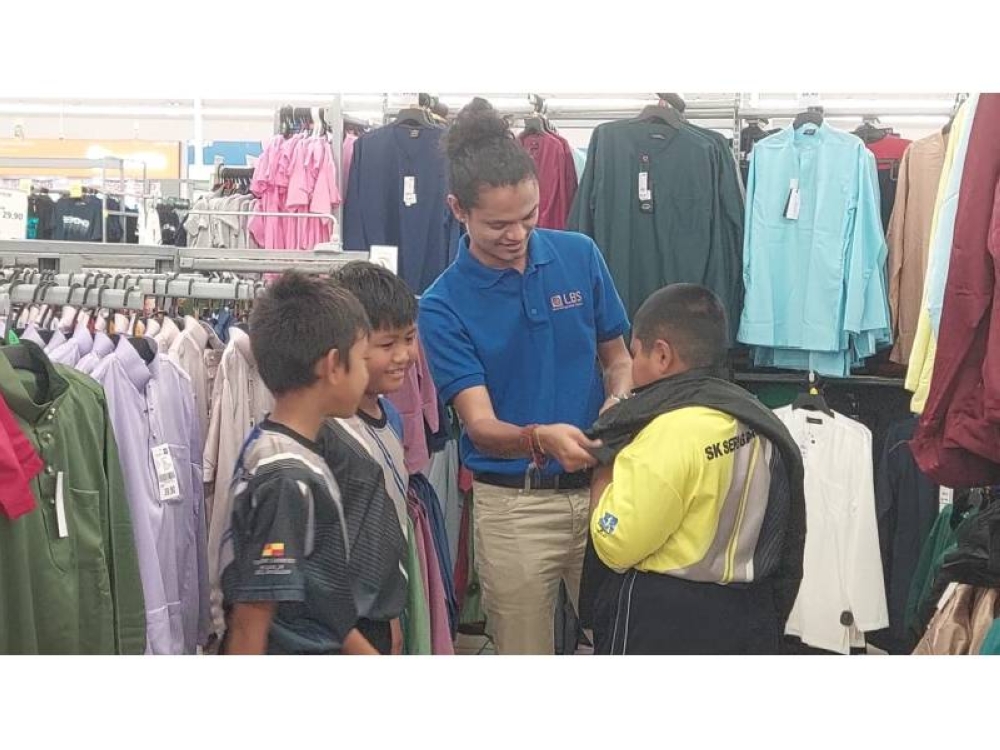 Kakitangan LBS menemani anak-anak yatim dan asnaf ini mencuba pakaian raya di salah sebuah pasar raya di Tanjong Karang.