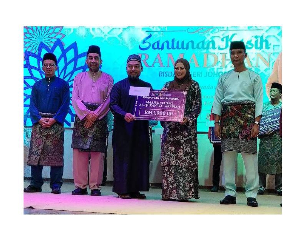 Noraini (dua dari kanan) menyerahkan sumbangan kepada wakil surau Parit Yusof Darat, pada majlis berkenaan.