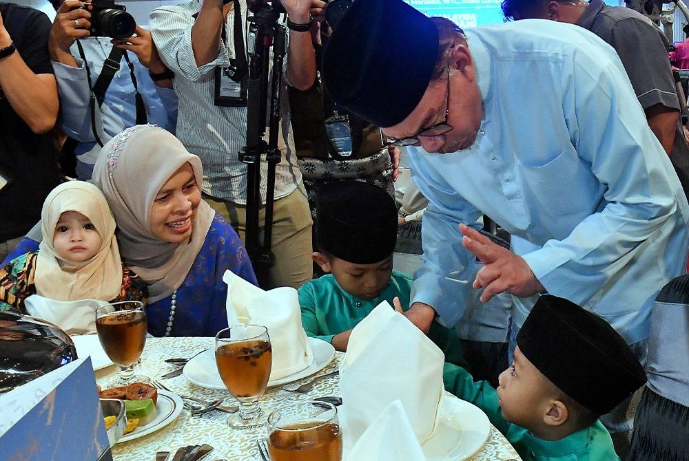 Anwar beramah mesra bersama anak yatim pada Majlis Berbuka Puasa bersama Pengamal Media dan Penggiat Seni di Dewan Merdeka Pusat Dagangan Kuala Lumpur pada Selasa. - Foto Bernama