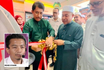 Che Mohamad Zulkifly sewaktu melancarkan mesin ATM di sebuah stesen minyak. - Foto daripada Pas Terengganu.