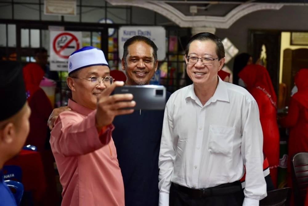 Guan Eng (kanan) dan Shah Headan (dua dari kanan) melayan permintaan penduduk Balik Pulau untuk bergambar bersama. - Foto FB Lim Guan Eng