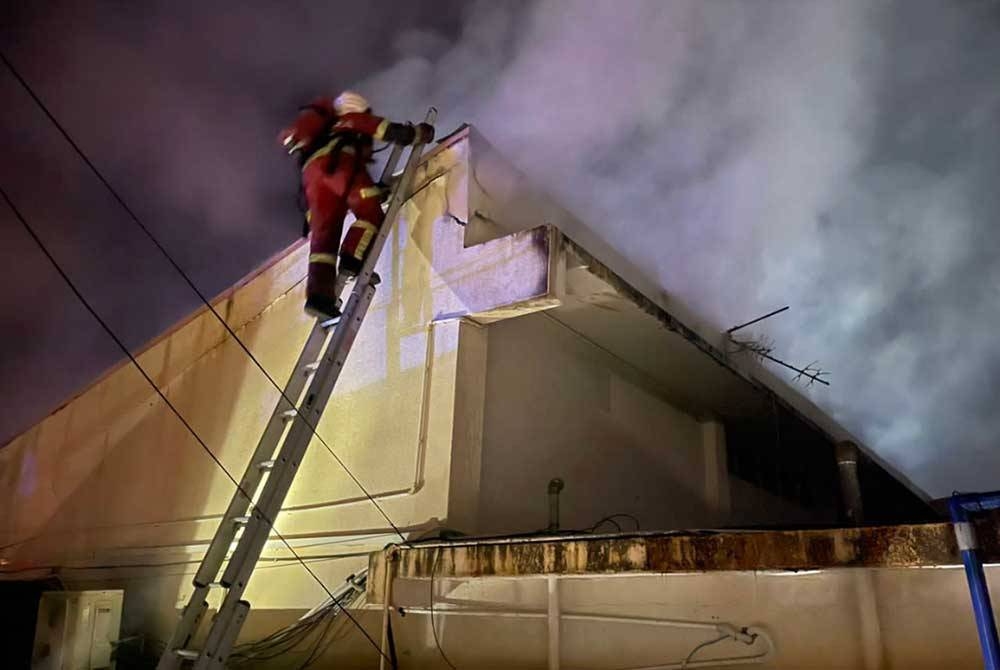Bomba berusaha memadam api dari atas bangunan. Foto: Ihsan JBPM