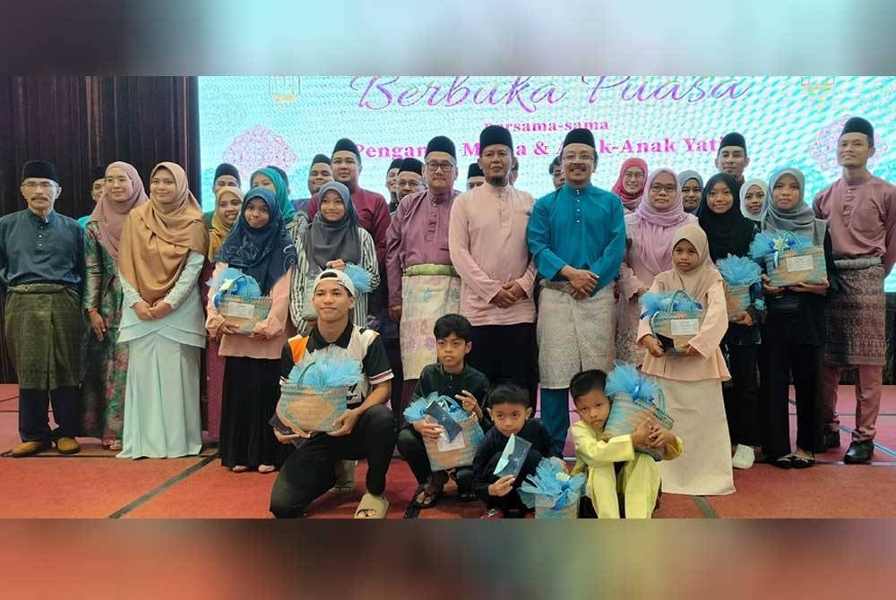 Saiful Zaini(barisan kedua, lima dari kanan)dan warga Paip bersama sebahagian anak yatim yang diraikan pada majlis berbuka puasa di sini pada Rabu.