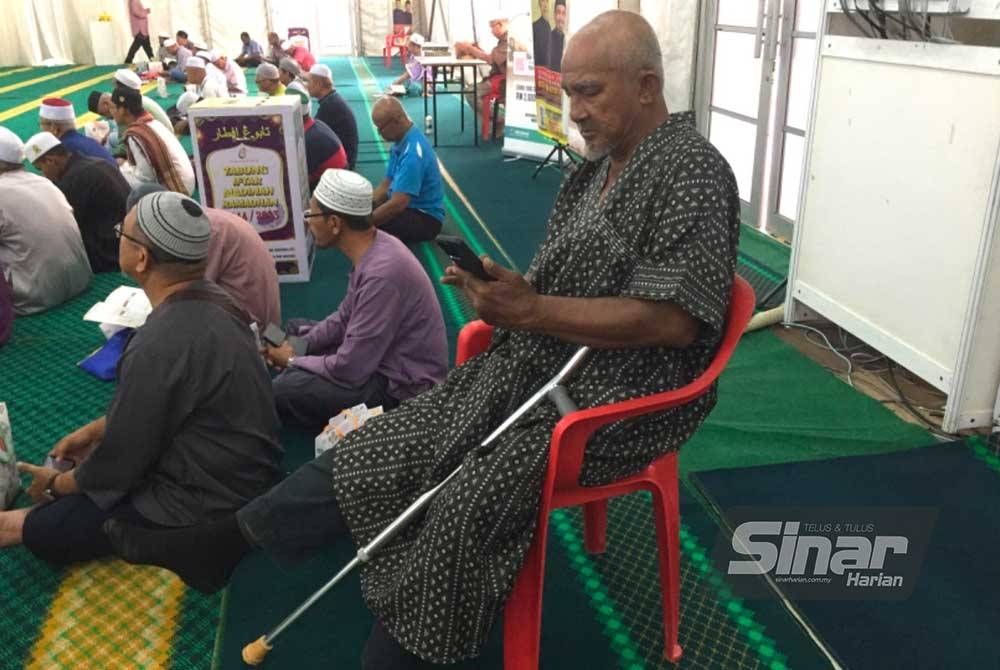 Che Kamal duduk atas kerusi sambil menyertai bacaan surah al-Insan pada World #QuranHour.