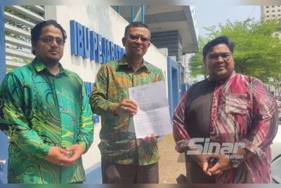 Muhamad (tengah) menunjukkan laporan yang dibuat di Ibu Pejabat Polis Daerah Kota Setar pada Khamis.