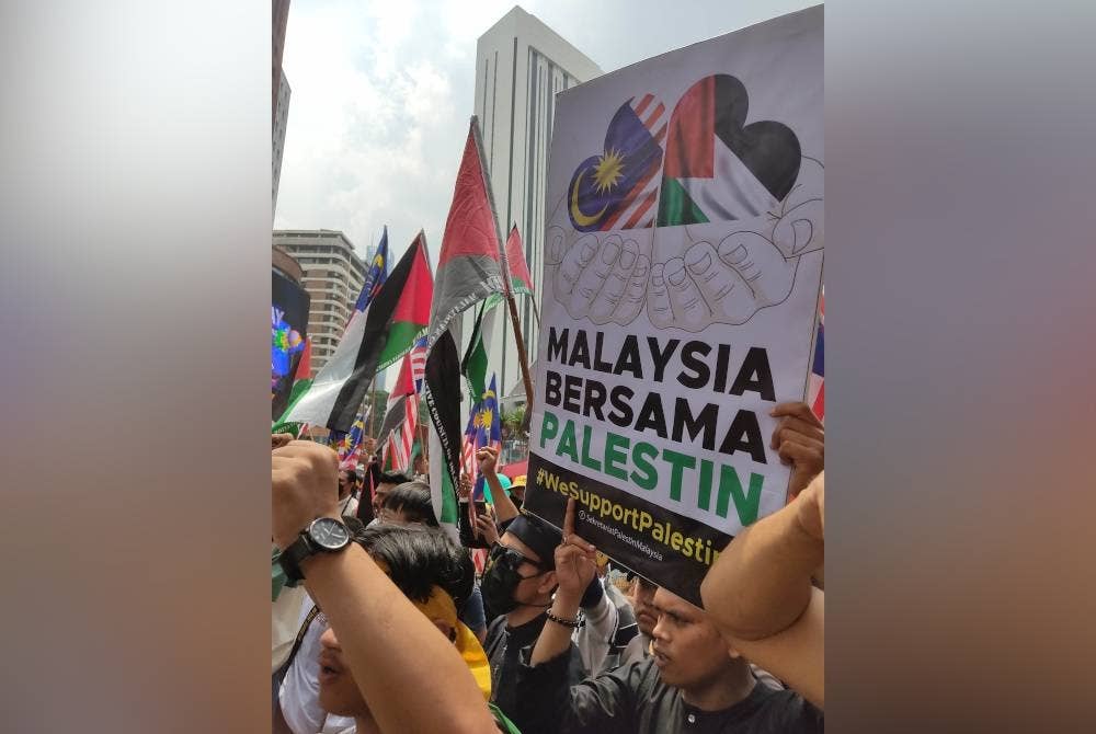 Antara plakad yang dibawa oleh peserta himpunan solidariti di ibu negara pada Jumaat.