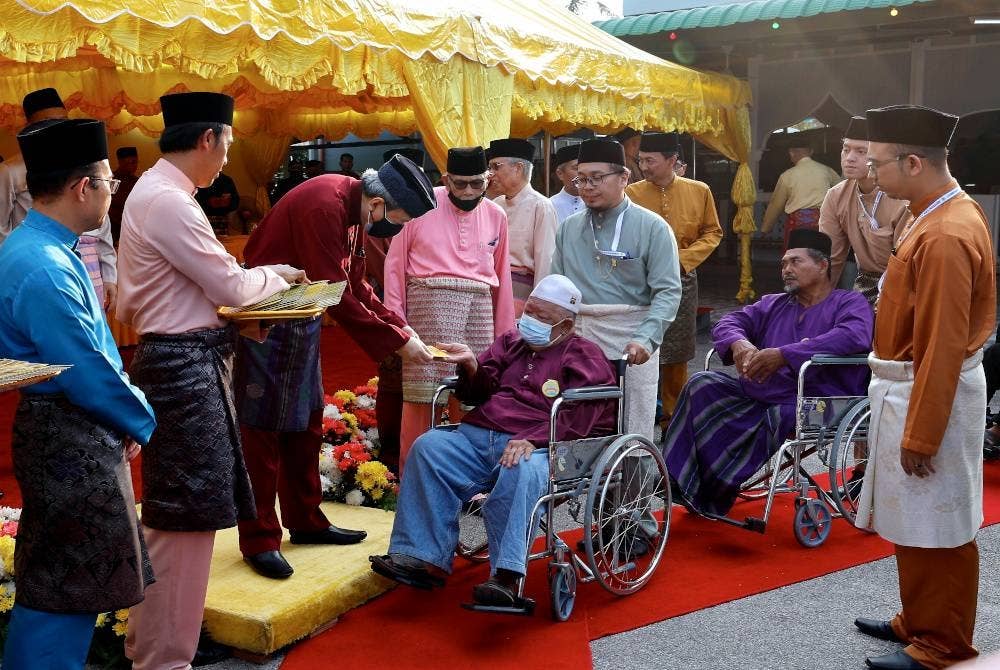 Sultan Sharafuddin Idris Shah (tiga, kiri) berkenan menyampaikan sumbangan Hari Raya kepada 426 asnaf fakir, miskin dan saudara baru Daerah Sabak Bernam. - Foto Bernama